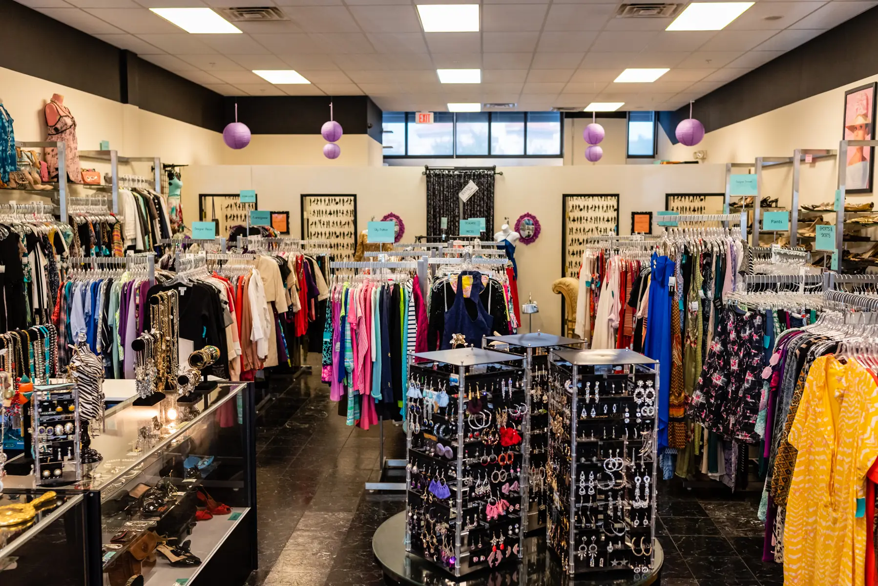 Inside Designer Divas: racks of clothing, a jewelry display and handbags
